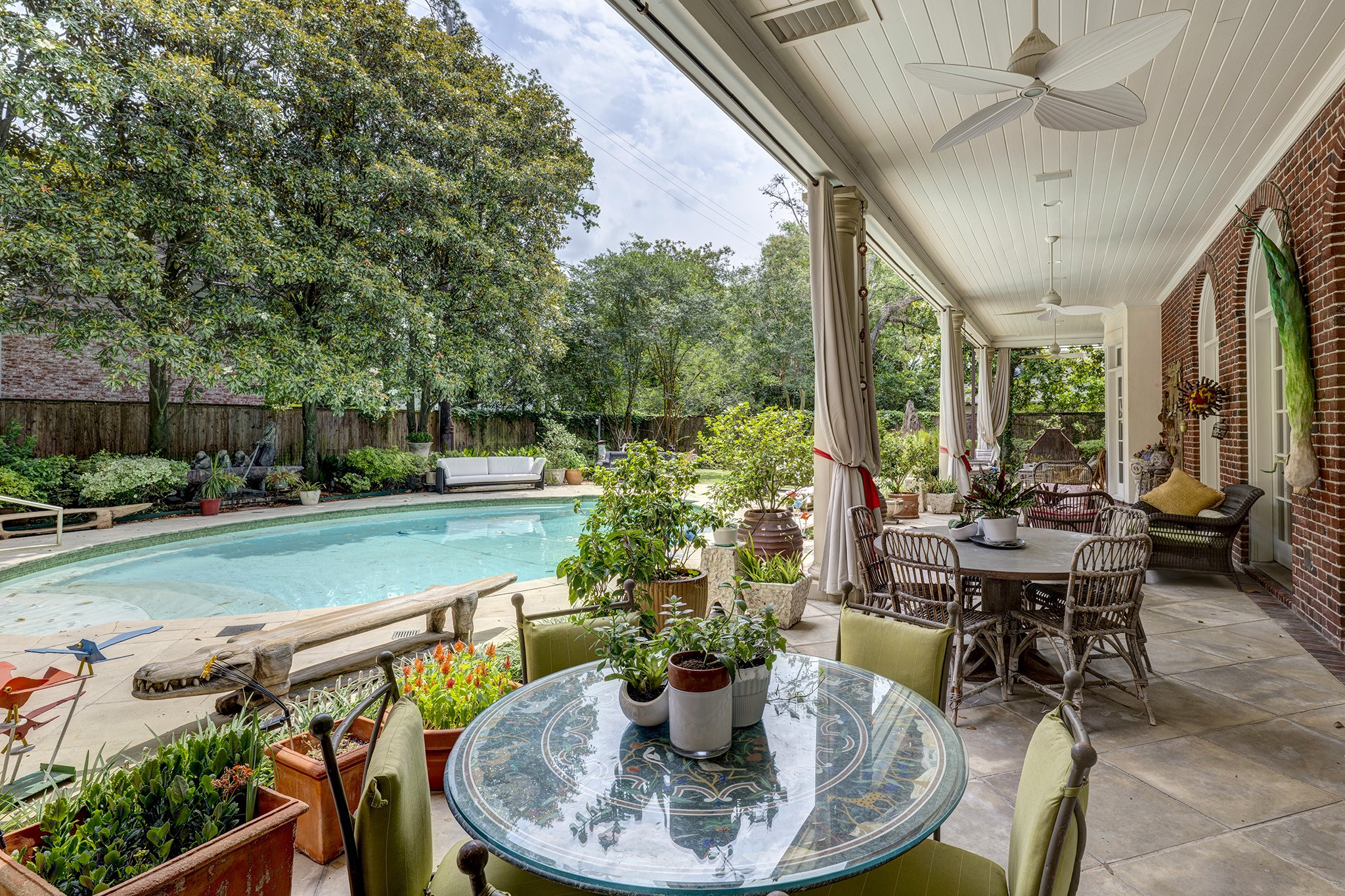 3653 Inverness Drive Houston, TX 77019 - Photo 37 of 39 In this private oasis, you can unwind and enjoy the shade provided by the magnolia trees, which offer privacy for the property. Take a refreshing dip and relax in the oval pool, featuring water features and a surrounding seating edge that enhances your experience.