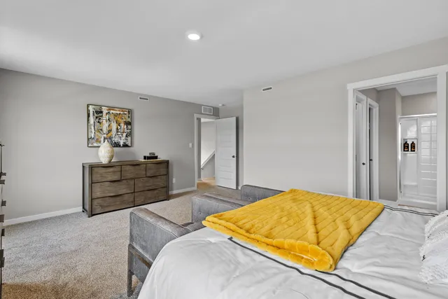 a bedroom with a bed and painting on the wall