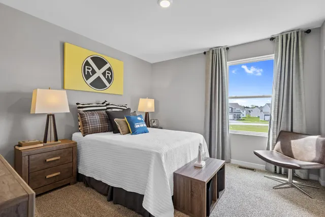 a bedroom with a bed and a lamp on dresser