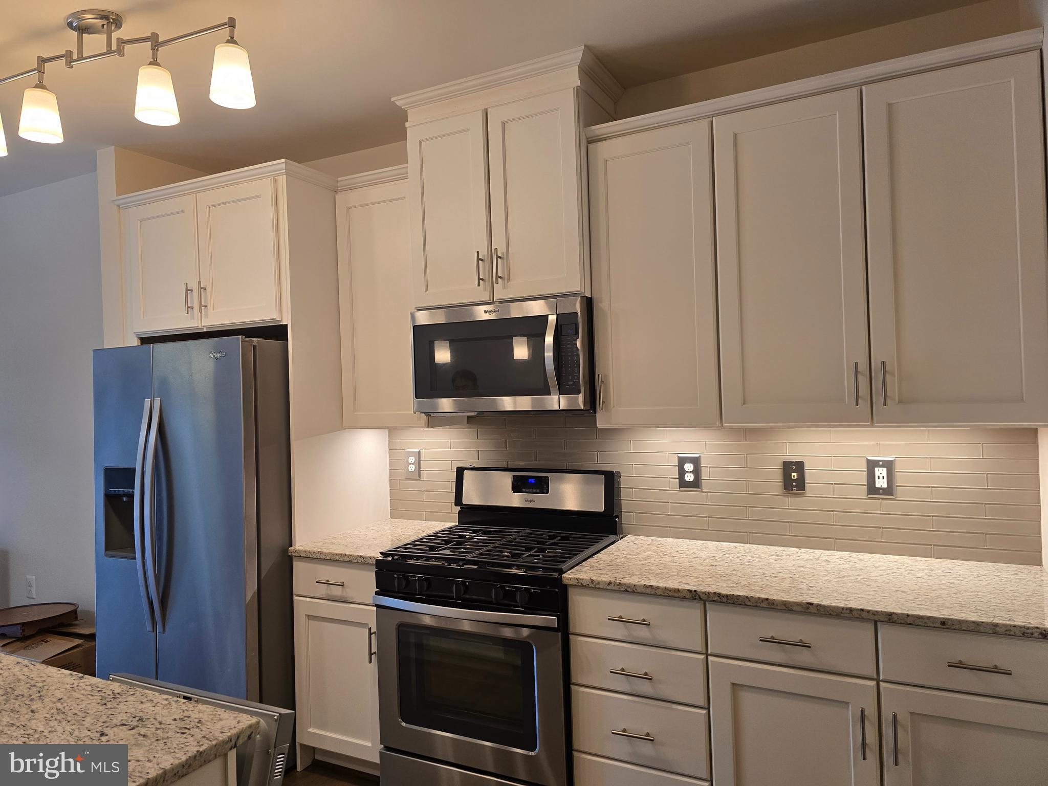 10530 Resort Road, Unit 101 Ellicott City, MD 21042 - Photo 3 of 13 a kitchen with granite countertop white cabinets and stainless steel appliances