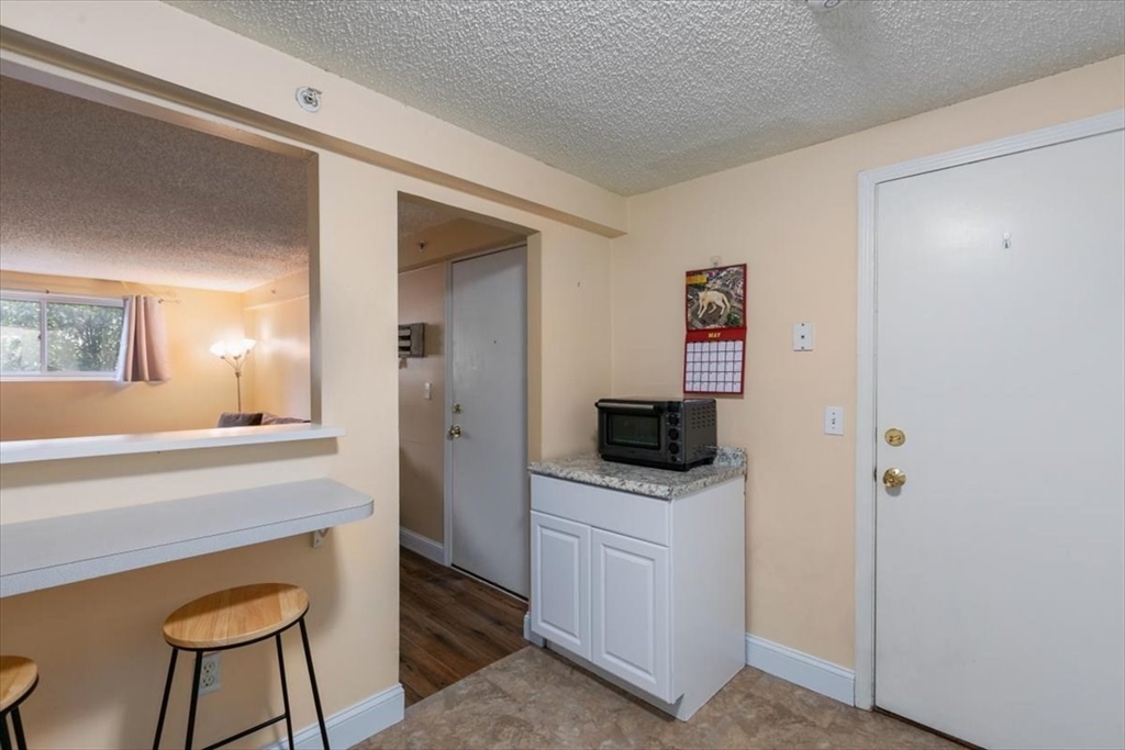 25 Clark's Road, Unit 101 Amesbury, MA 01913 - Photo 12 of 32 a kitchen with a microwave a stove and a refrigerator