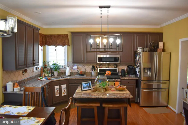 a kitchen with stainless steel appliances granite countertop a sink refrigerator and microwave