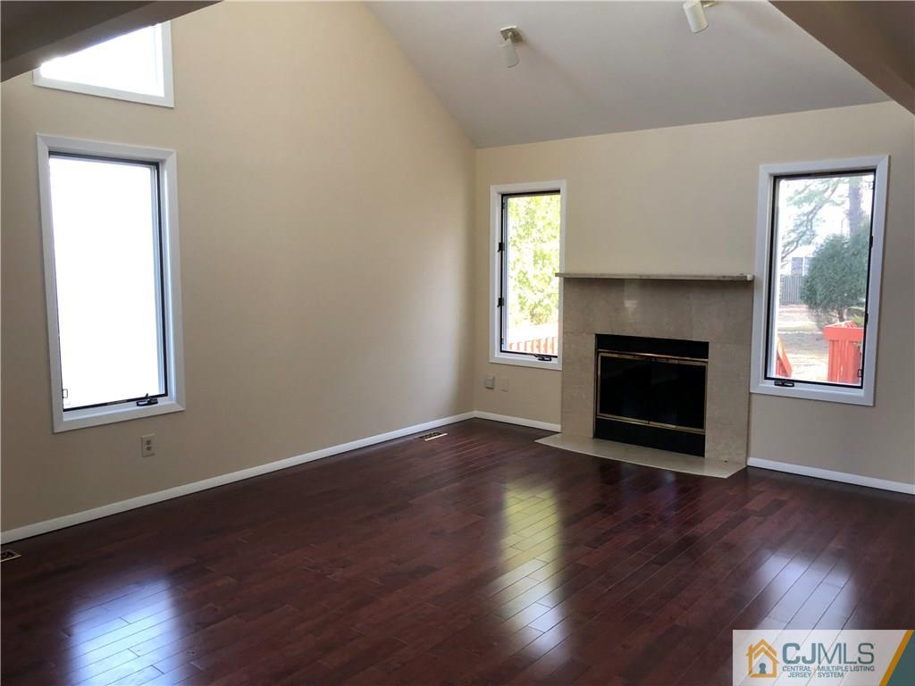 16 Shelly Road Old Bridge, NJ 08857 - Photo 5 of 25 an empty room with wooden floor fireplace and windows