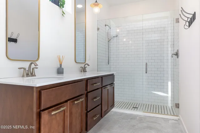 a bathroom with a double vanity sink mirror and shower
