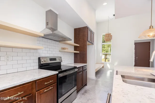 a kitchen with stainless steel appliances kitchen island granite countertop a sink and a stove