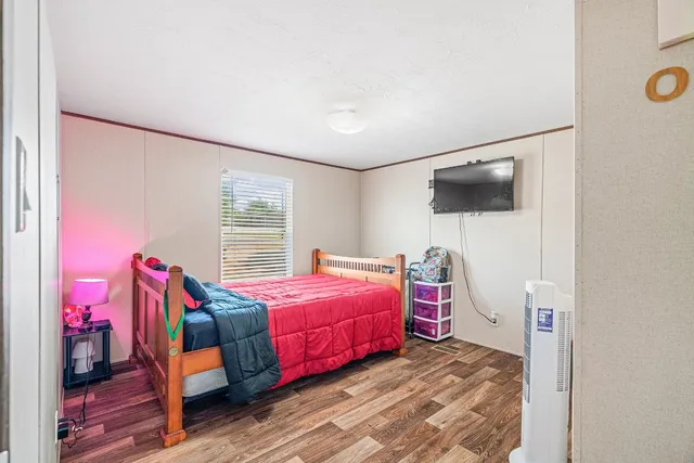 a bedroom with a bed and a flat screen tv