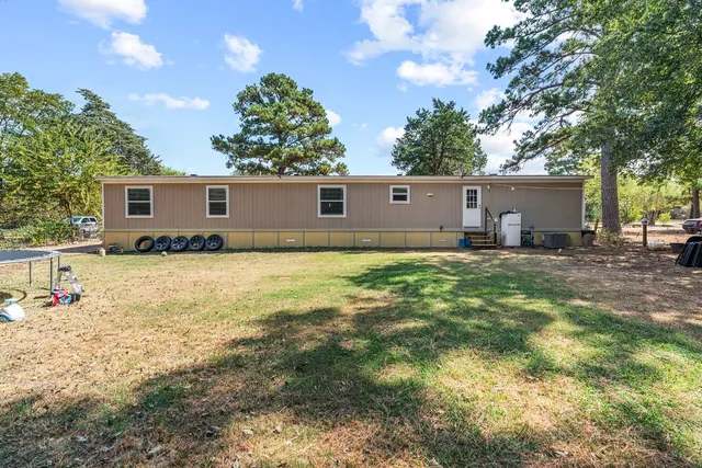 a backyard of a house with yard and outdoor seating