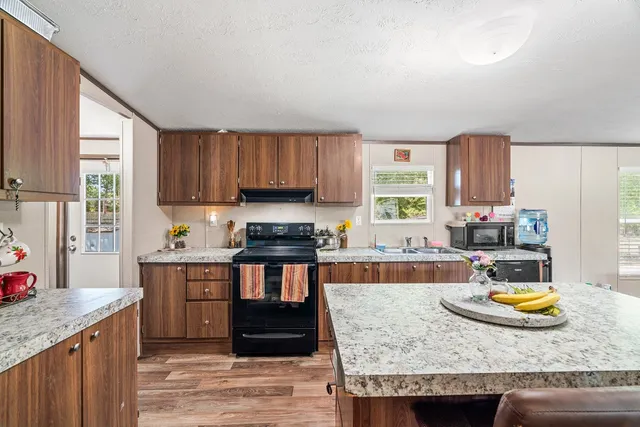 a kitchen with a stove a sink a refrigerator and wooden cabinets