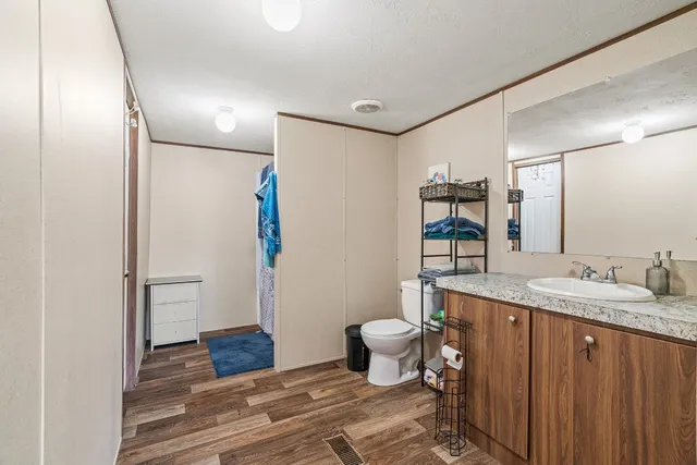 a bathroom with a sink toilet a mirror and shower