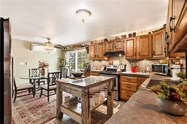 a kitchen with stainless steel appliances granite countertop a sink a stove and a microwave
