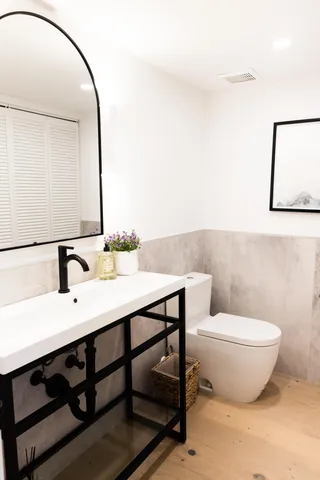 a bathroom with a toilet a sink and mirror