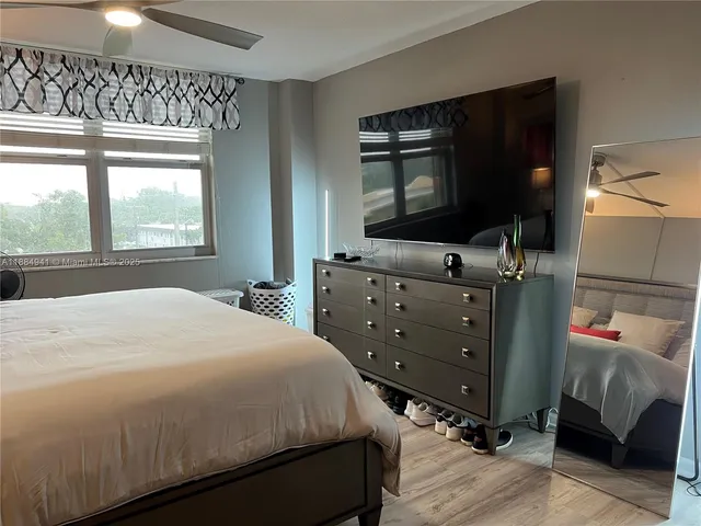 a bedroom with a bed and a flat tv screen on dresser