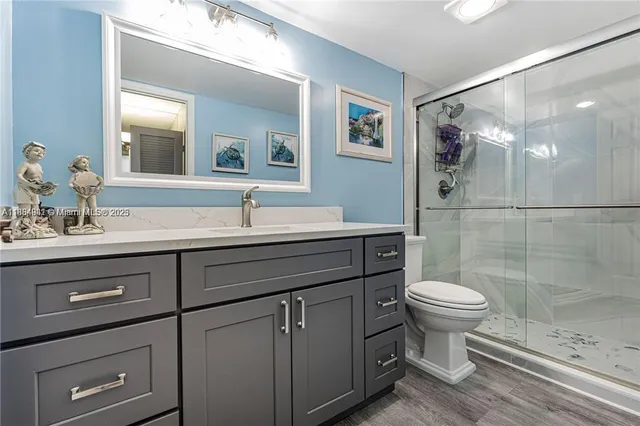 a bathroom with a sink toilet a mirror and shower