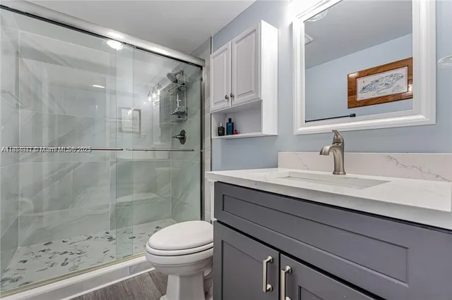 a bathroom with a sink a toilet and shower