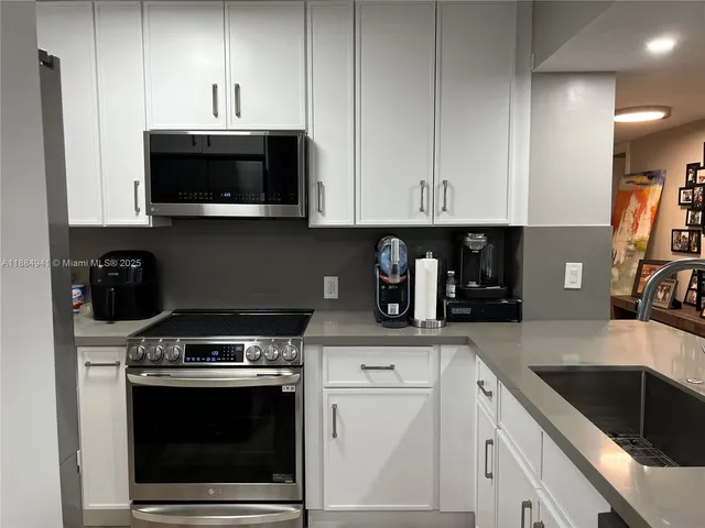 a kitchen with stainless steel appliances granite countertop a sink a stove a microwave and cabinets