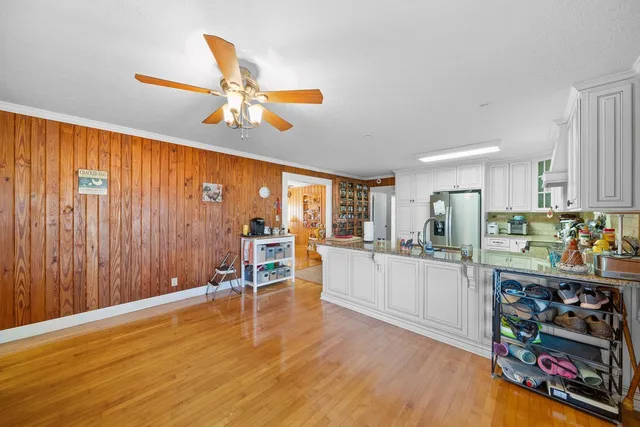 a kitchen with stainless steel appliances wooden floor and chandelier