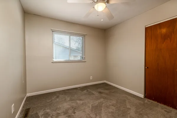 an empty room with closet and a bathroom space