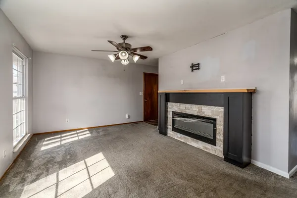 a view of an empty room with a fireplace and a window