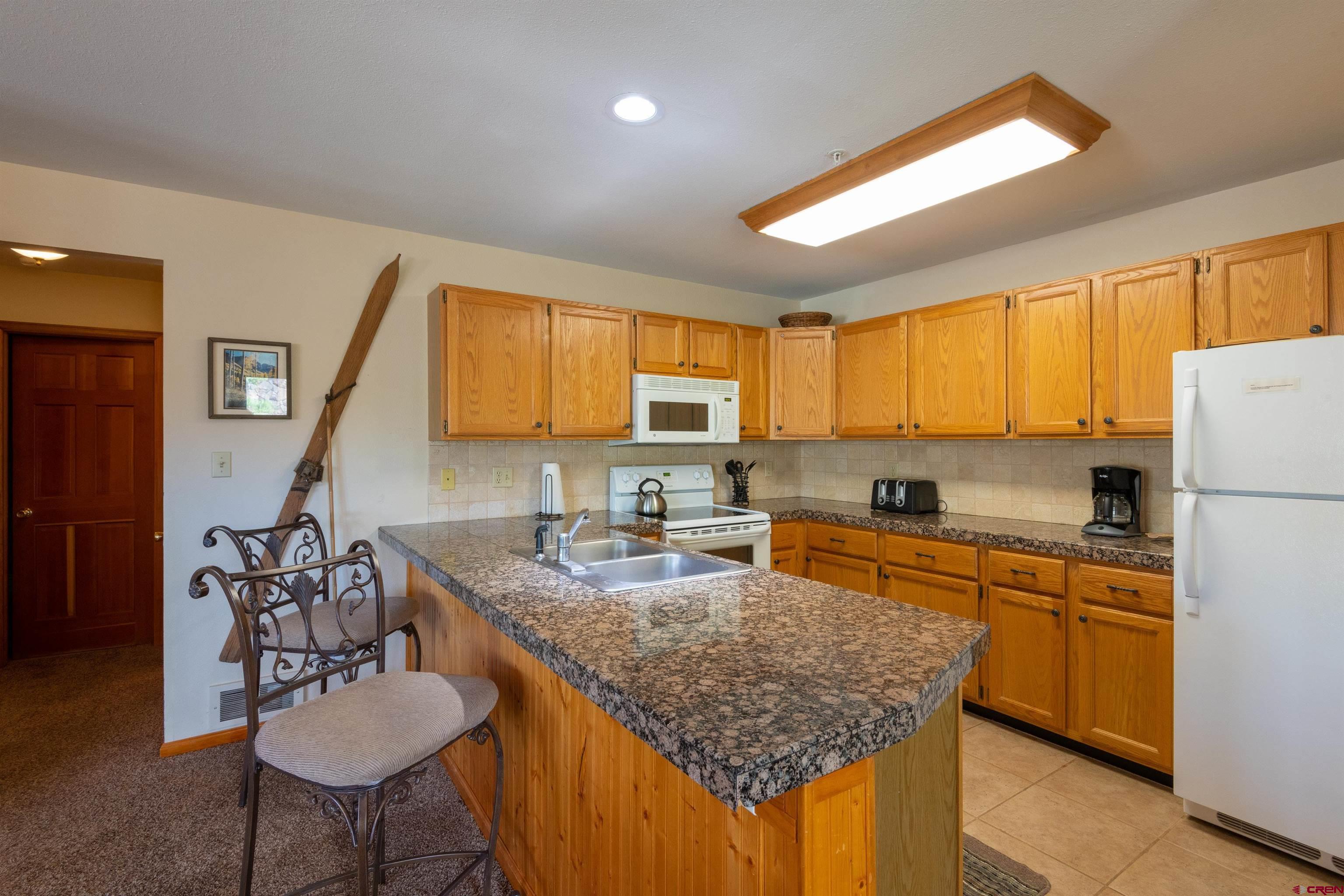 33 Castle Road, Unit 3 Crested Butte, CO 81225 - Photo 7 of 34 a kitchen with stainless steel appliances granite countertop a sink stove and refrigerator