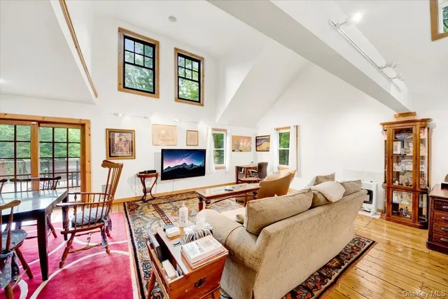 a living room with furniture two window and a flat screen tv