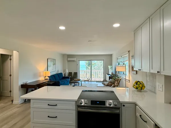 a kitchen with a stove a sink a refrigerator and windows