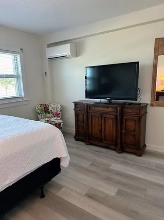 a spacious bedroom with a bed and a flat screen tv