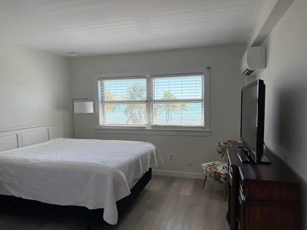 a bedroom with a bed tv and a window
