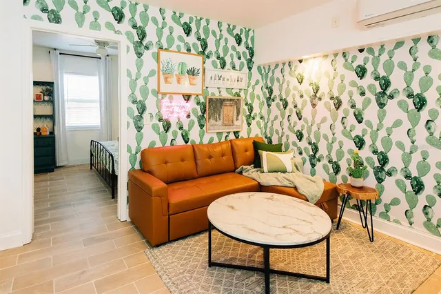 a living room with furniture and a painting on the wall