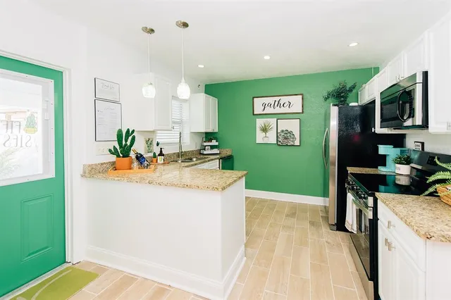 a view of a kitchen with kitchen island a counter top space a sink and appliances