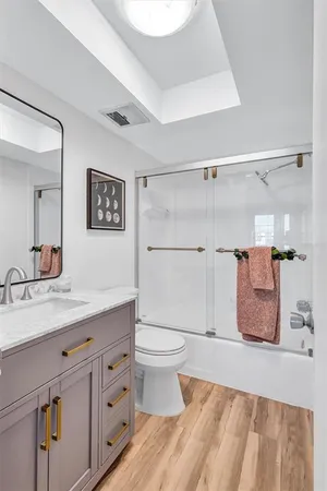 a bathroom with a granite countertop sink a toilet and shower