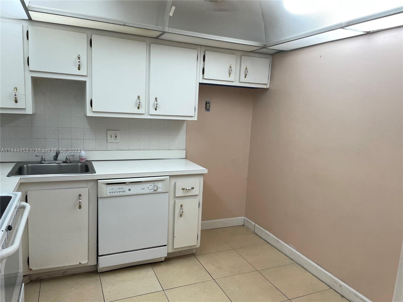 Inverrary Lauderhill, FL 33319 - Photo 16 of 23 a kitchen with cabinets and white appliances