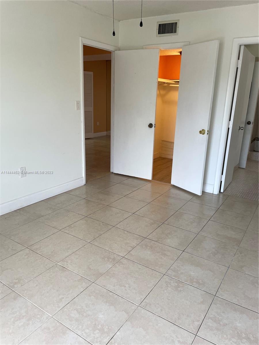 Inverrary Lauderhill, FL 33319 - Photo 9 of 23 an empty room with mirror and a fan