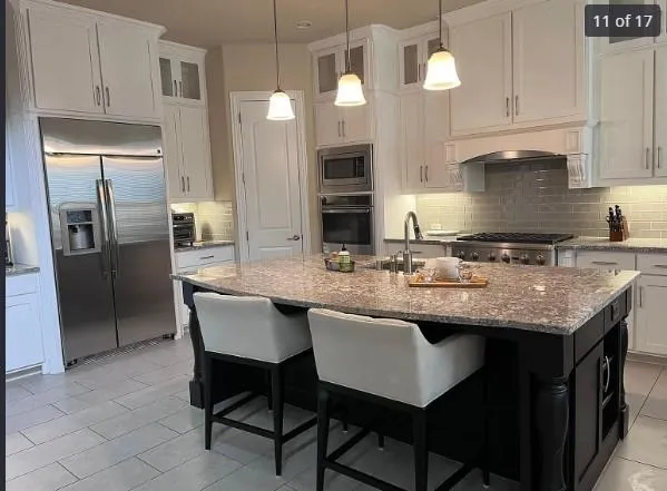 a kitchen with granite countertop stainless steel appliances a sink stove and refrigerator
