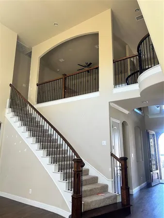 a view of staircase with railing and white walls