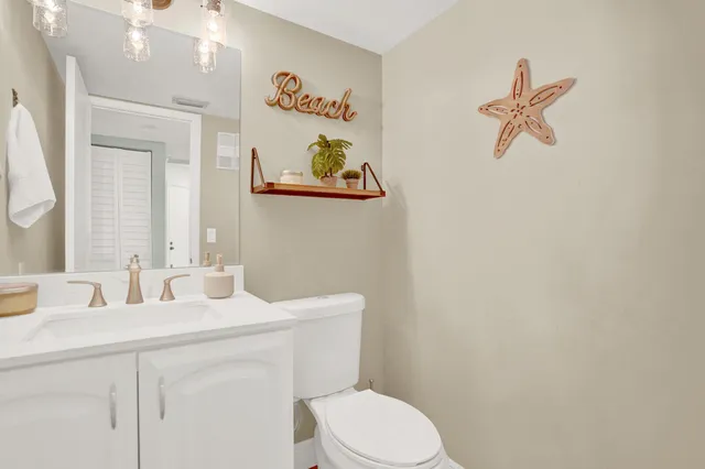 a bathroom with a sink mirror vanity and toilet