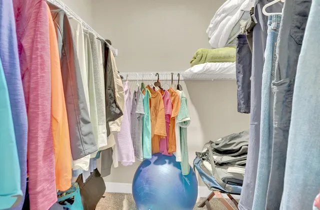 a view of walk in closet with clothes and shoes