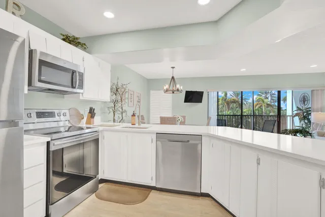 a kitchen with white cabinets and sink