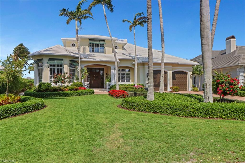 2621 Windward Way Naples, FL 34103 - Photo 1 of 37 a front view of a house with garden
