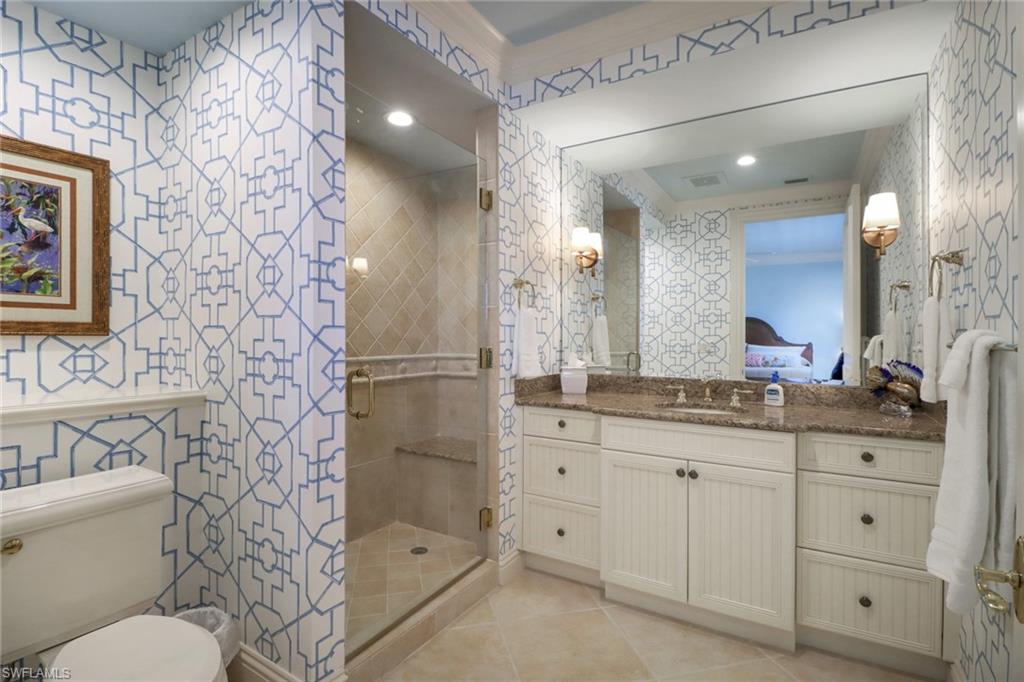 2621 Windward Way Naples, FL 34103 - Photo 24 of 37 a bathroom with a granite countertop sink a toilet a mirror a vanity and shower