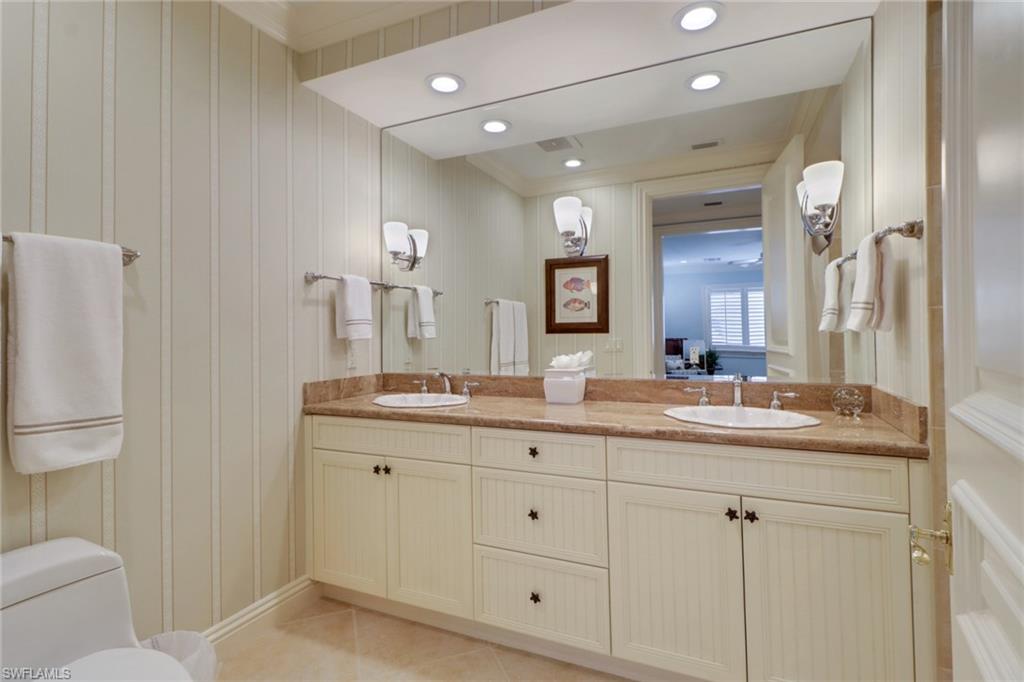 2621 Windward Way Naples, FL 34103 - Photo 26 of 37 a bathroom with a granite countertop sink a toilet and a mirror