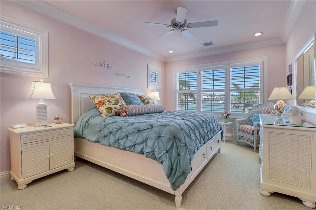 2621 Windward Way Naples, FL 34103 - Photo 28 of 37 a bedroom with a bed and a chandelier