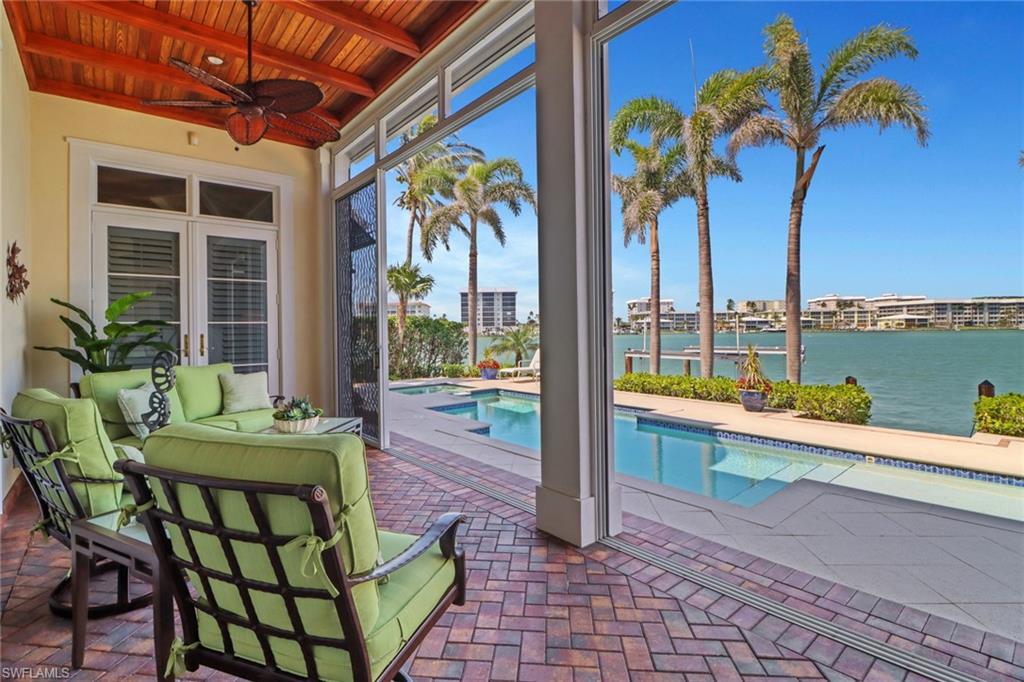 2621 Windward Way Naples, FL 34103 - Photo 29 of 37 a view of a chairs and table in patio with swimming pool
