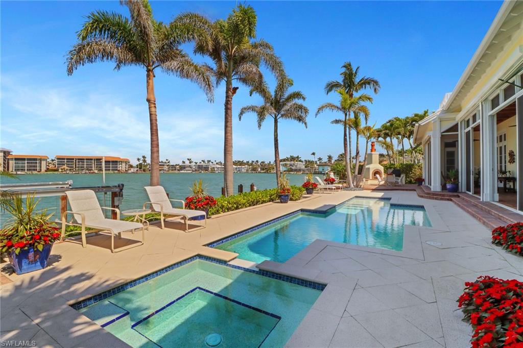 2621 Windward Way Naples, FL 34103 - Photo 5 of 37 a view of a swimming pool with a lounge chairs