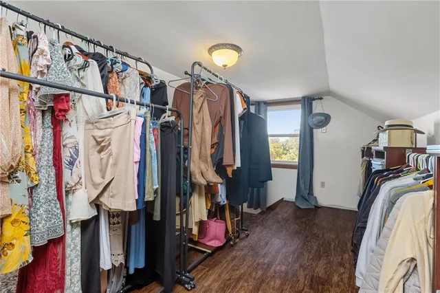 a view of walk in closet with clothes and shoes