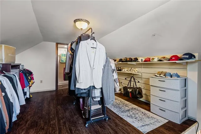 a view of walk in closet with clothes and shoes