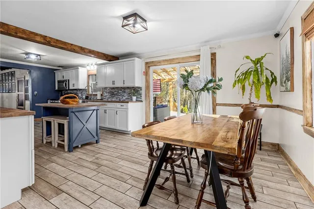 a kitchen with stainless steel appliances granite countertop table chairs and wooden floor