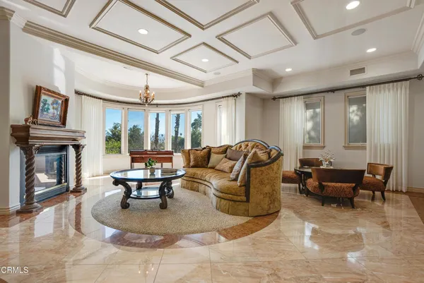 a living room with furniture a fireplace and a large window