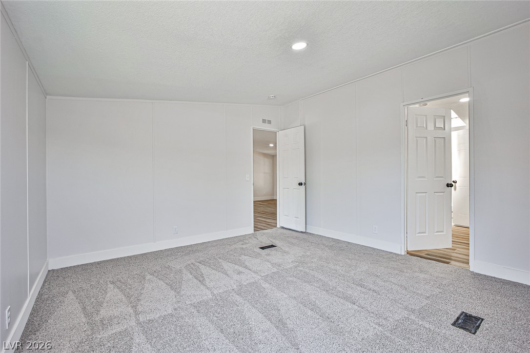273 Aztec Lane Henderson, NV 89015 - Photo 17 of 28 A spacious room offers ample potential, featuring freshly carpeted floors and bright recessed lighting.