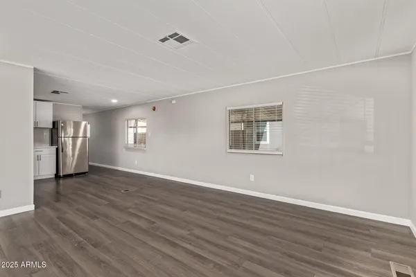 a view of a big room with wooden floor and a window