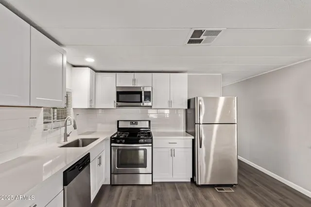 a kitchen with white cabinets and white appliances